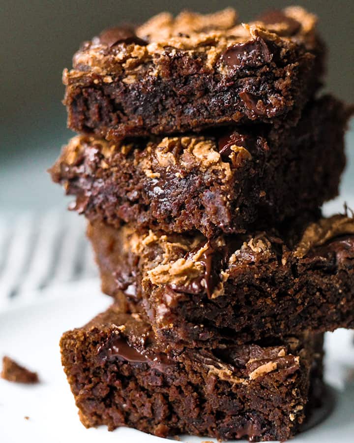 Stack of black bean brownies topped with a peanut butter swirl.