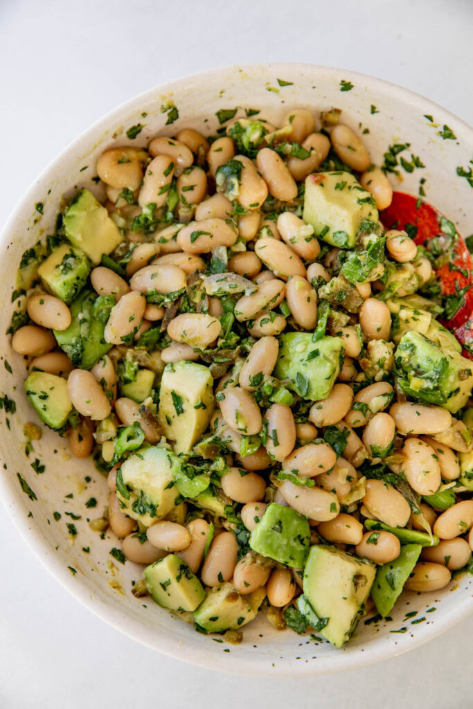 Mixing the white beans, herbs, pickled jalapeño, and avocado.