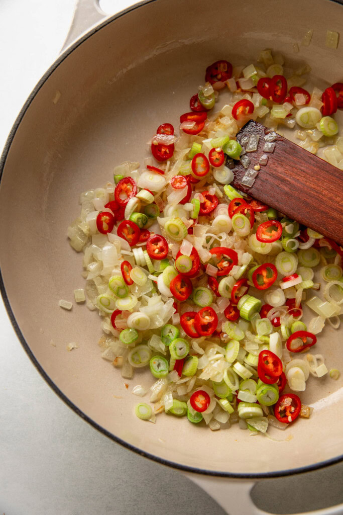 Sauteing onions, scallions and chilies together.