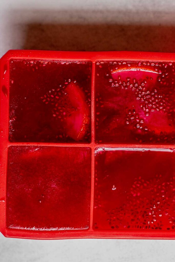 Frozen hibiscus tea and chia seeds mixed in a ice cube tray.