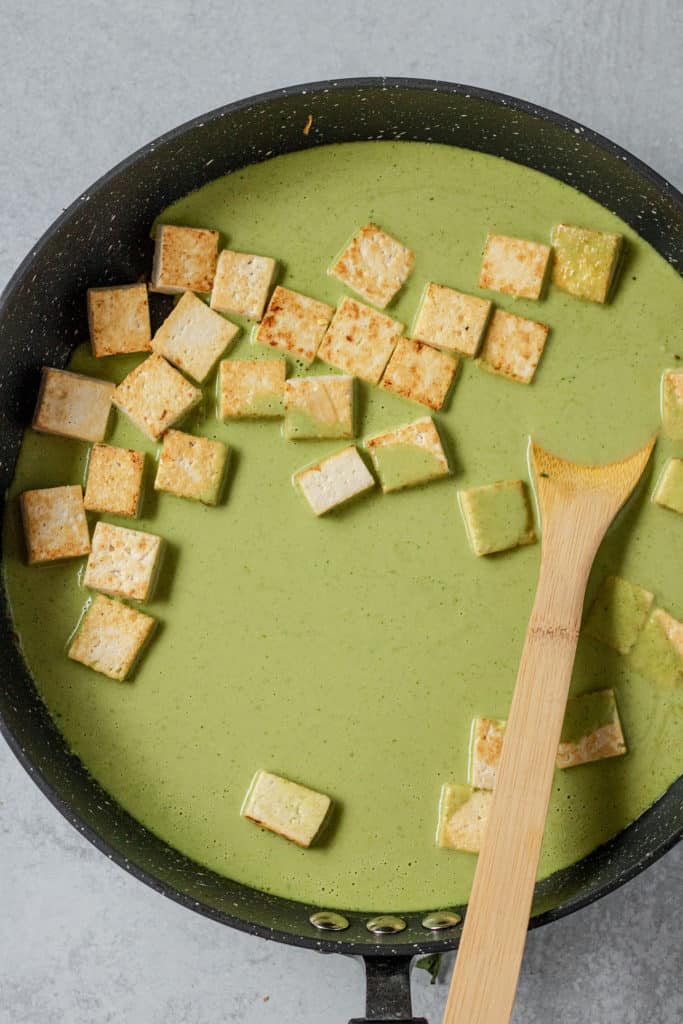 Tofu simmering in the coconut sauce.