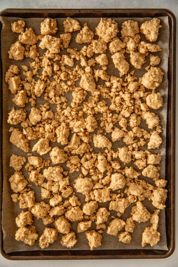 Sheet pan filled with seasoned and prepped tofu pieces ready to bake.