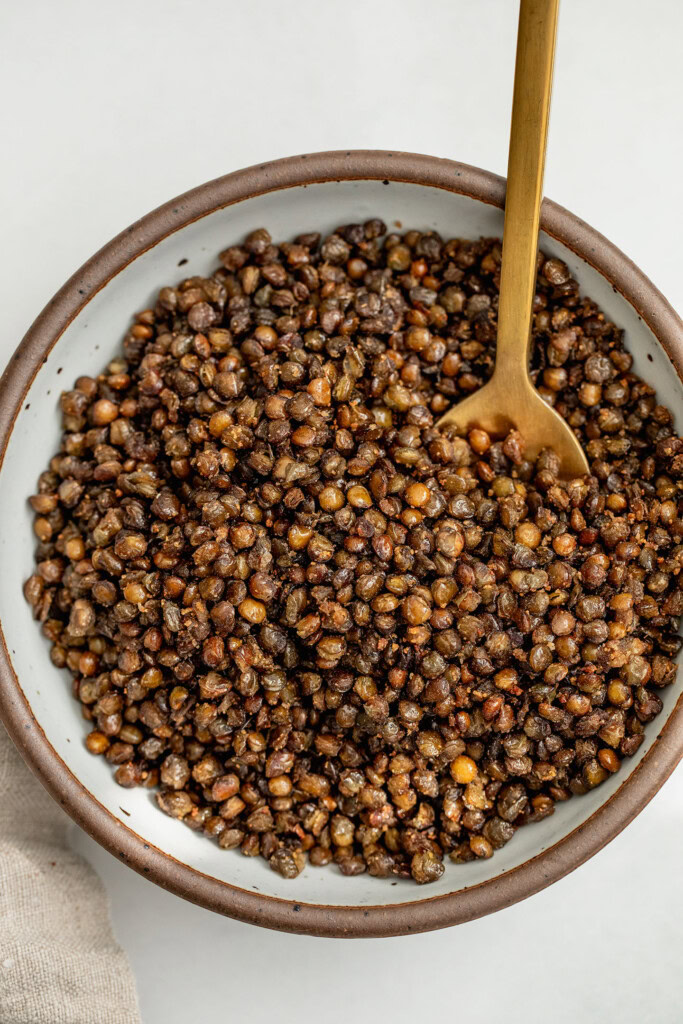 Bowl of crispy lentils with a spoon in it. 