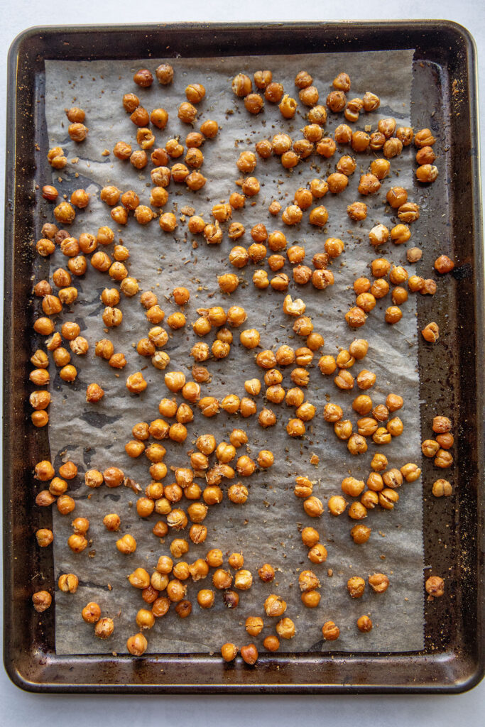 Crispy baked chickpeas on a baking tray out of the oven.