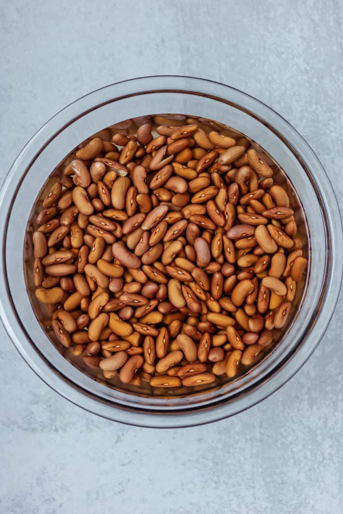 Bowl of red beans being soaked in a glass bowl with water.