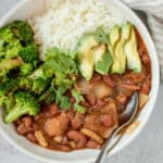 Close up of the bowl of habichuelas guisadas with rice broccoli, avocado and cilantro.