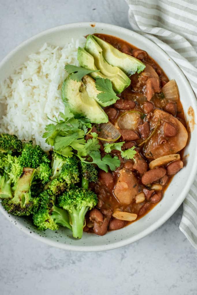 Big white bowl of rice, habichuelas guisadas, broccoli and avocado.