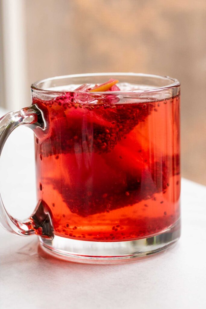 Mug with ice cubes melting in it after adding boiling water to the mug.