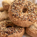 Close up shot of a stack of high protein bagels on a white plate.