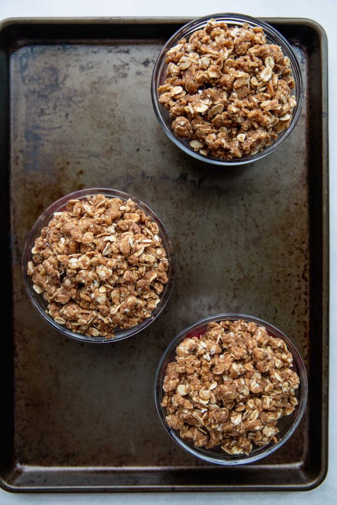 Baking tray with 3 unbaked crumbles.