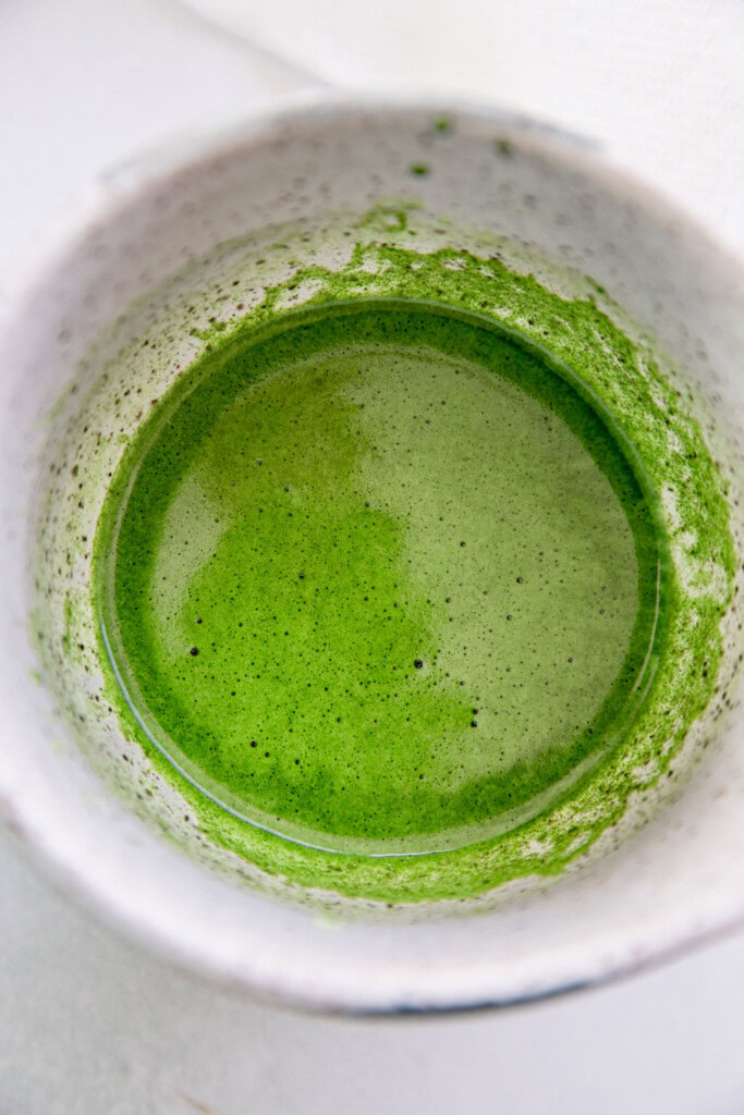 Whisked matcha and water in a matcha bowl.