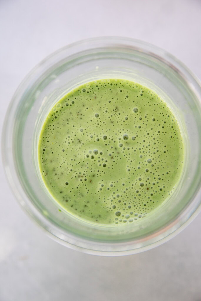 The matcha milk and chia seeds mixed together in a storage container.