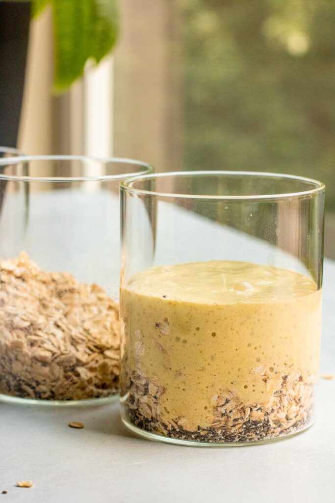 Pouring the mango milk into each jar with rolled oats.