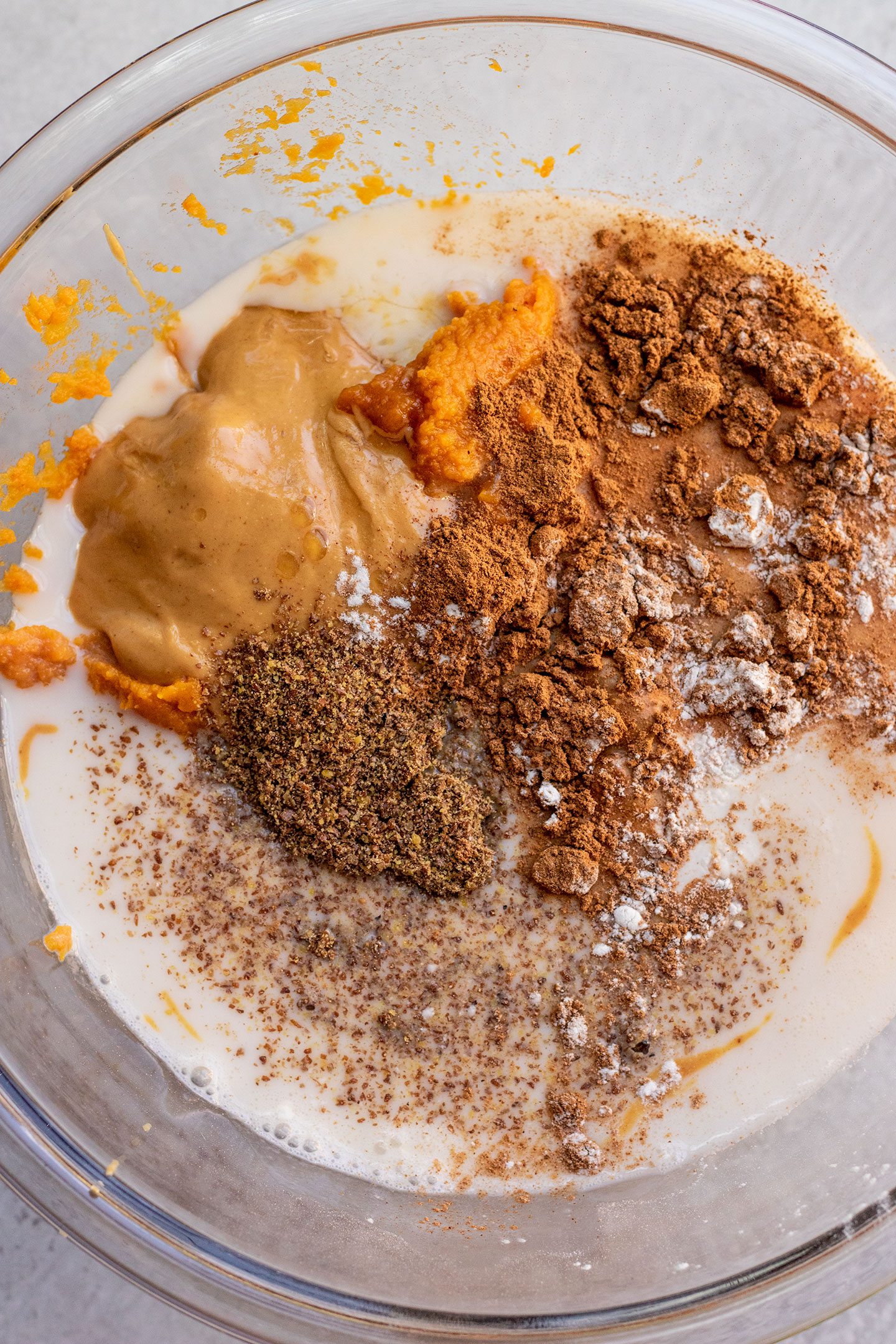 Bowl with pumpkin, milk, peanut butter, maple syrup, and pumpkin spice layered in.