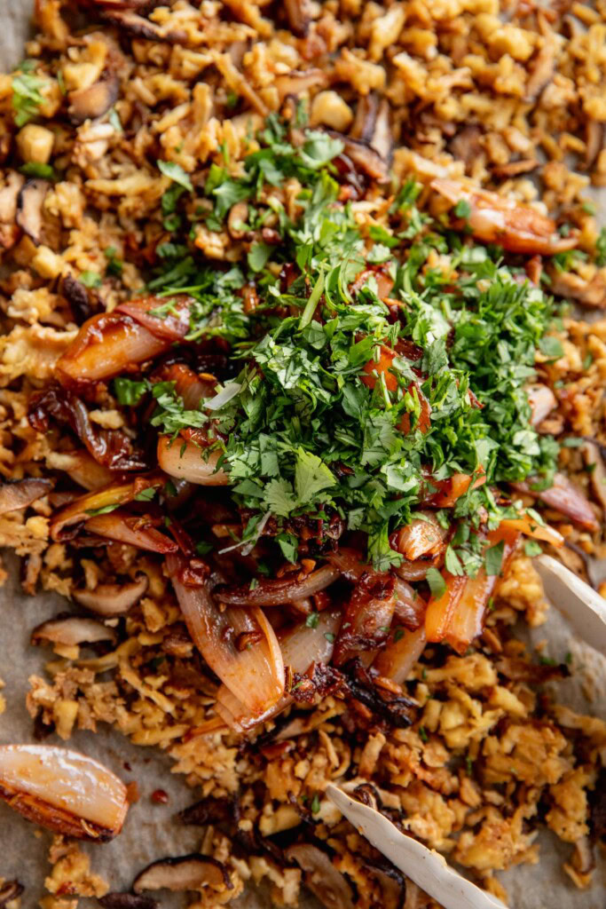 One tray topped with roasted shredded tofu, mushrooms, spiced sauteed shallots and cilantro.