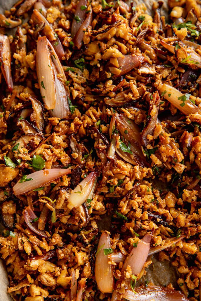 Shredded tofu and charred shallots mixed together in one pan.