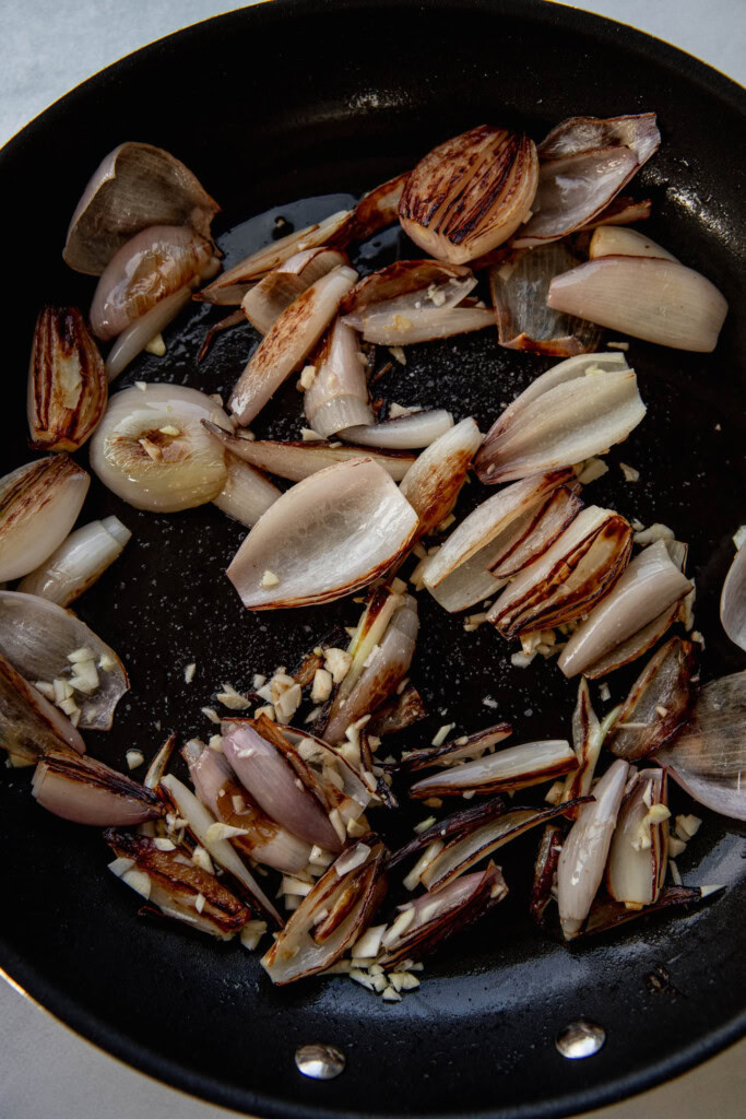 Sauteeing the shallots with minced garlic in a pan.