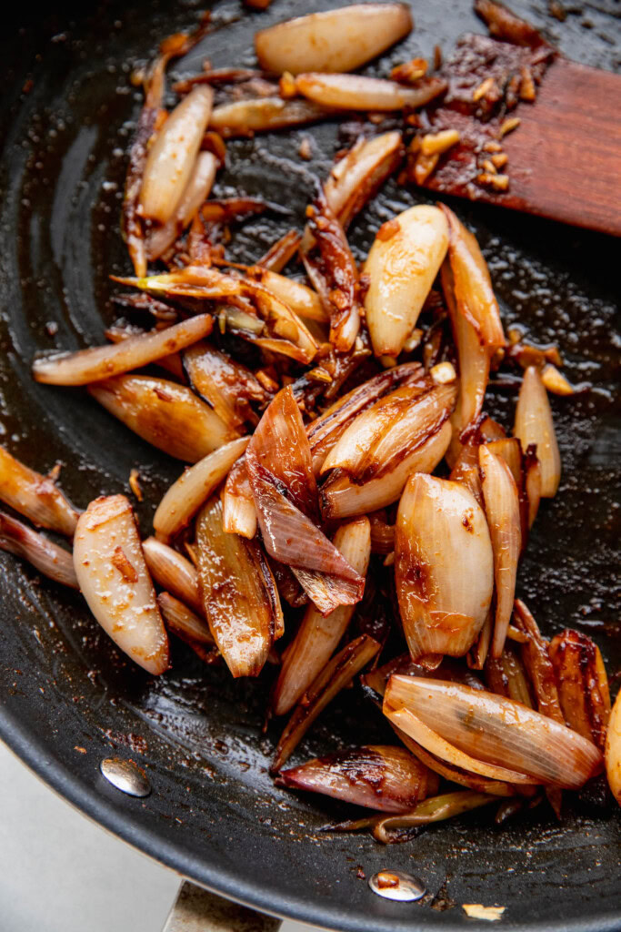 Sauteed spiced shallots in a pan.
