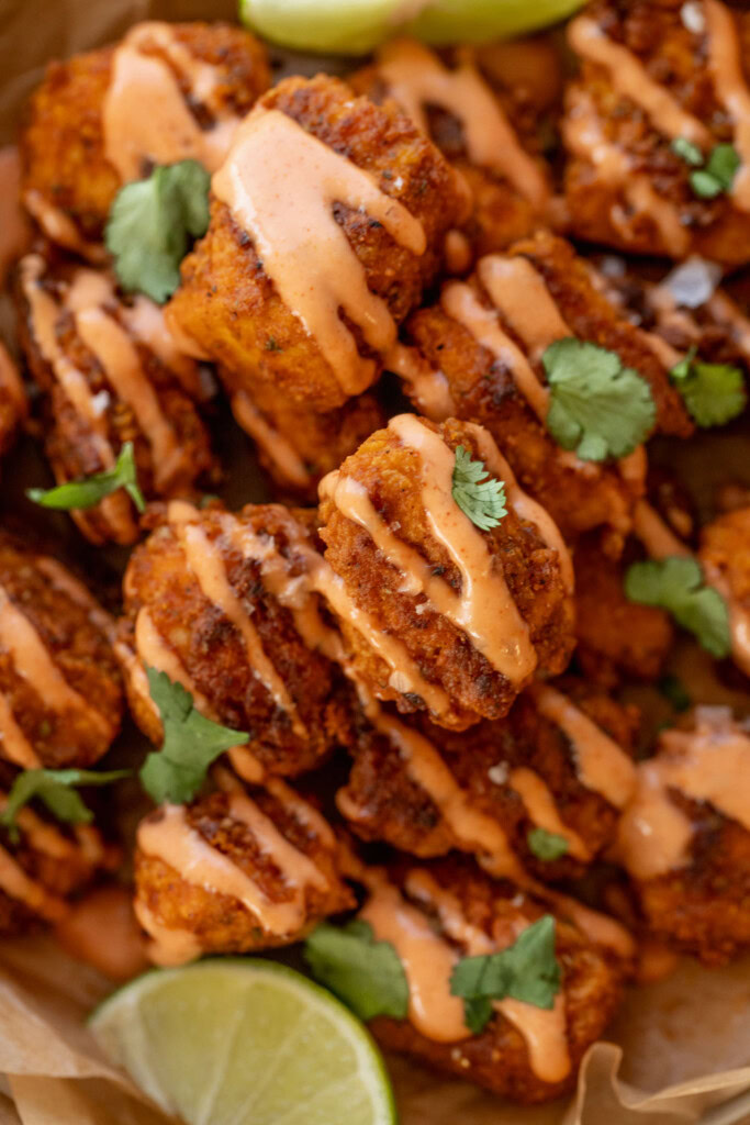 Close up of a plate of pica tofu covered in a drizzle of mayo ketchup and some cilantro leaves.
