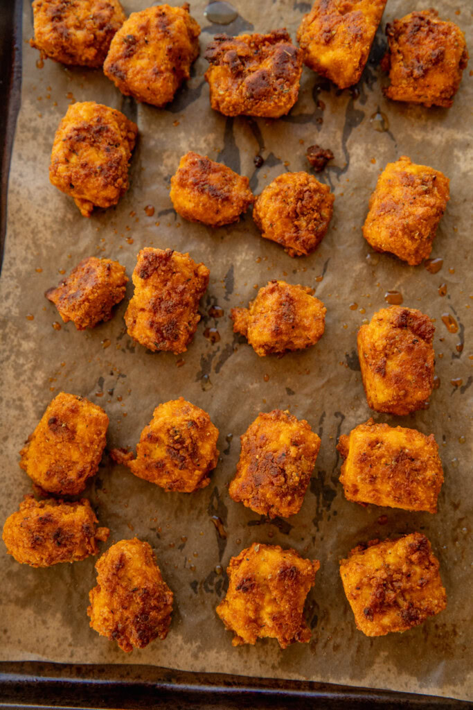 Fully baked spiced tofu chunks on a baking tray.