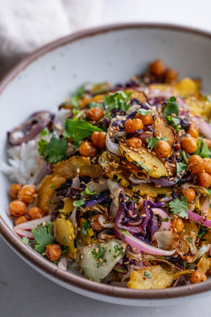 Bowl of rice topped with roasted cabbage, squash, chickpeas and marinated onions.