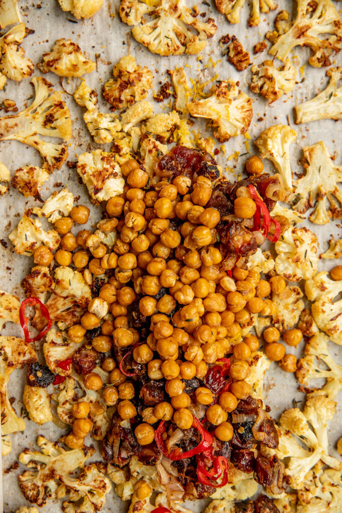 Combining chickpeas, cauliflower and dates on a baking tray.