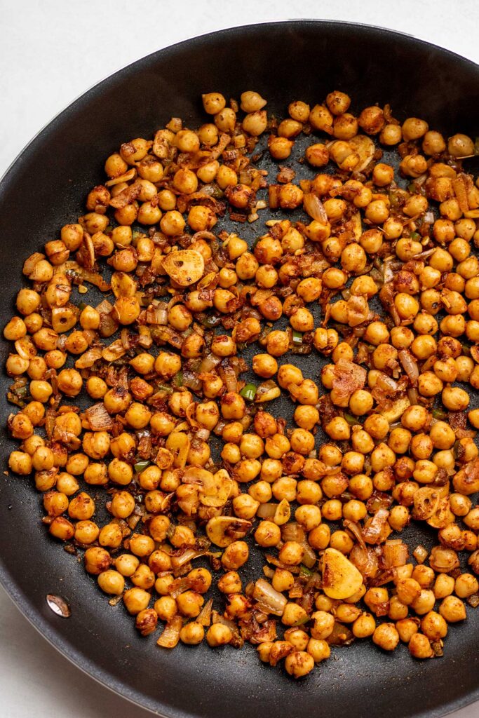 Allowing the chickpeas to sear in a single layer on a skillet.