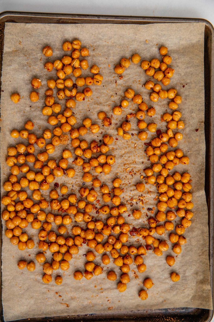 Seasoned chickpeas on a baking tray.