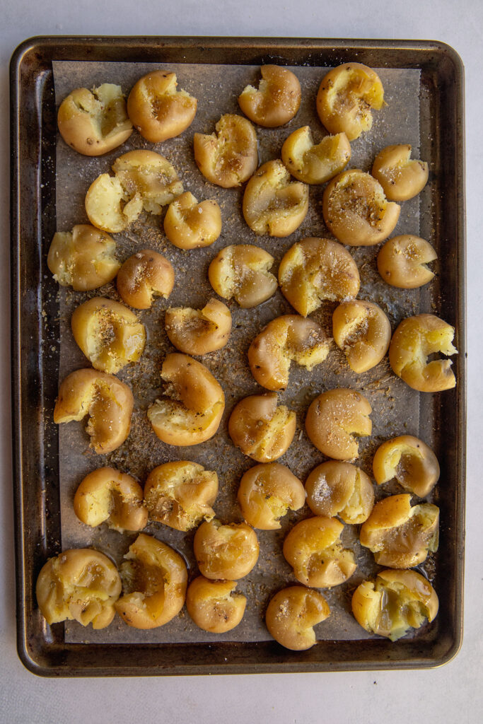 Smashed potatoes on a baking tray.