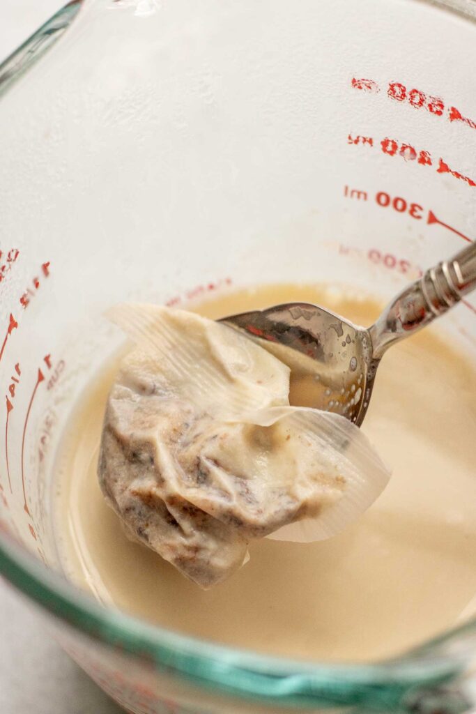 Soaking a tea bag in a cup of warm milk.