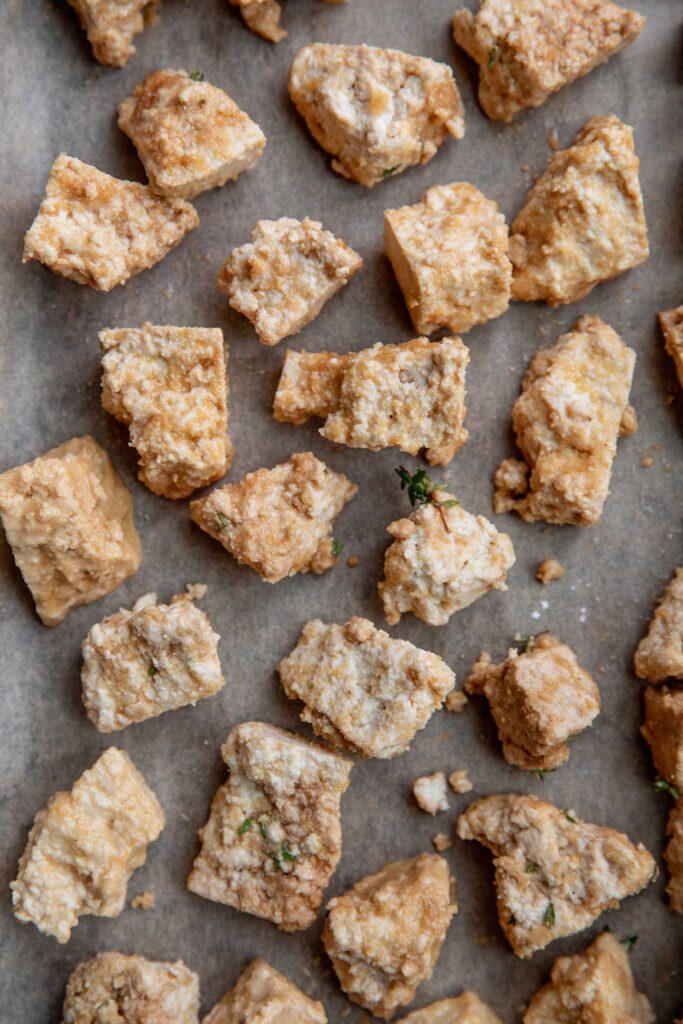 Seasoned tofu chunks on a baking tray.
