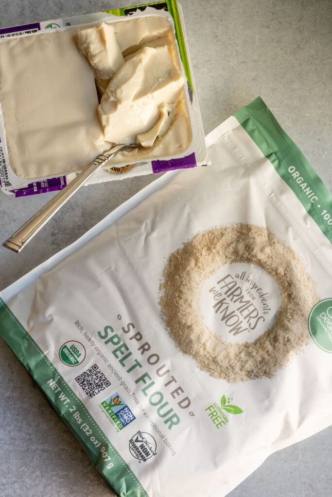 Silken tofu and a bag of One Degree Organics Spelt Flour on a working surface.