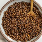 Bowl of crispy roasted lentils with a spoon tucked into them.