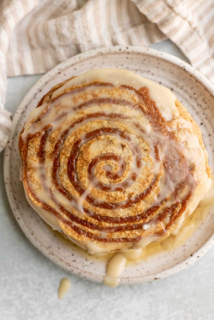 Top down view of the swirl on the top of a stack of cinnamon roll pancakes.
